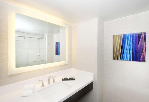 拉斯维加斯Embassy Suites by Hilton Las Vegas的一间带水槽的浴室和墙上的绘画