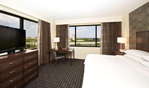 棕榈滩花园Embassy Suites by Hilton Palm Beach Gardens PGA Boulevard的配有一张床和一台平面电视的酒店客房