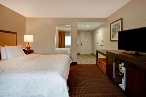 皇后区Hampton Inn NY-JFK的酒店客房设有两张床和一台平面电视。