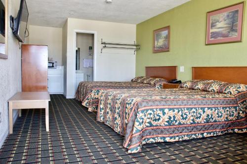 阿林顿Executive Inn of Arlington, Near AT&T Stadium的酒店客房设有两张床和一张桌子。