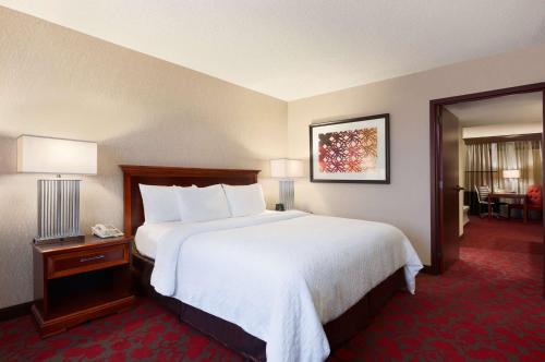 赫恩登Embassy Suites by Hilton Dulles Airport的酒店客房带一张大床,带白色床单