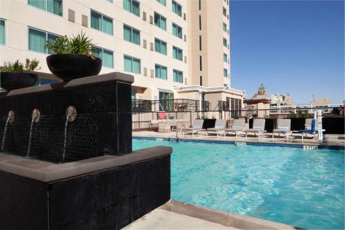 埃尔帕索DoubleTree by Hilton El Paso Downtown的一座大楼前的游泳池,带喷泉