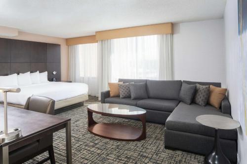 东叙拉古DoubleTree by Hilton Hotel Syracuse的酒店客房设有一张沙发和一张床