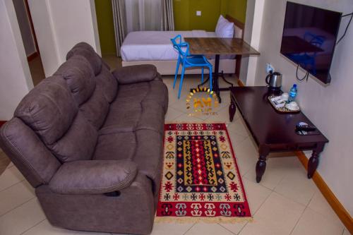 NarokWalabi Mara Hotel的客厅配有沙发、桌子和床。
