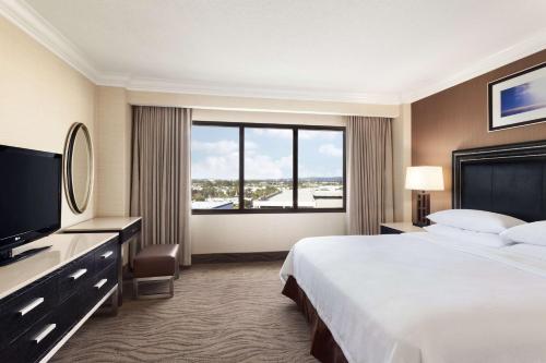 尔湾Embassy Suites by Hilton Irvine Orange County Airport的一间酒店客房,设有一张大床和一个大窗户