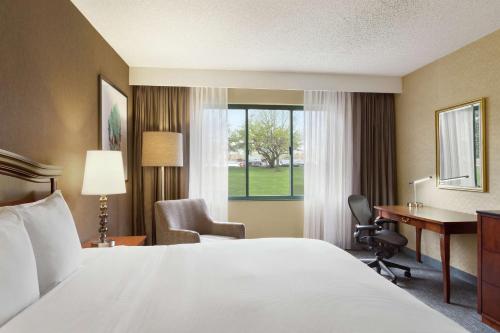 诺维DoubleTree by Hilton Hotel Detroit - Novi的配有一张床、一张书桌和一扇窗户的酒店客房