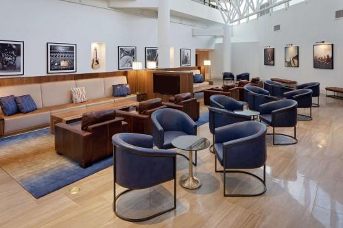 纳什维尔希尔顿纳什维尔机场酒店的一个带蓝色椅子的候机室的沙龙