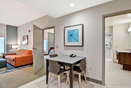 麦迪逊Home2 Suites By Hilton Madison Huntsville Airport的一间客厅,客厅内配有桌椅