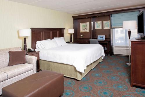科科莫科科莫希尔顿恒庭旅馆&套房酒店的酒店客房设有一张大床和一张沙发。