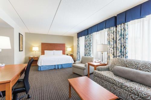 莫尔黑德城莫尔黑德城希尔顿恒庭酒店的配有一张床和一张书桌的酒店客房