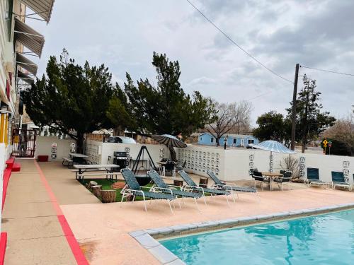 摩押Apache Motel的一个带躺椅和桌子的游泳池