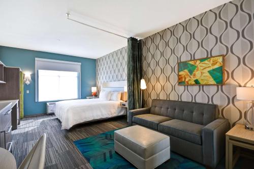 佩里斯堡Home2 Suites by Hilton Perrysburg Levis Commons Toledo的酒店客房,配有床和沙发