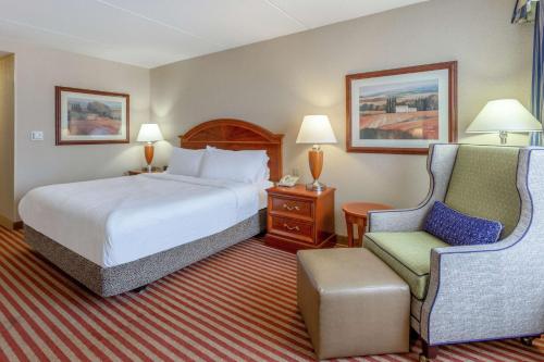 科洛尼尔海茨里士满南/南方公园希尔顿花园旅馆的配有一张床和一把椅子的酒店客房