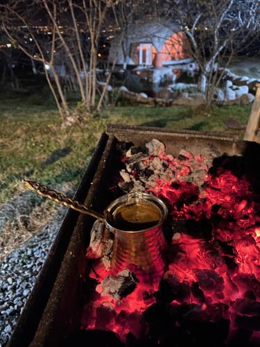 萨潘贾Phalesia Glamping Otel的红颜料坐在火炉边的锅