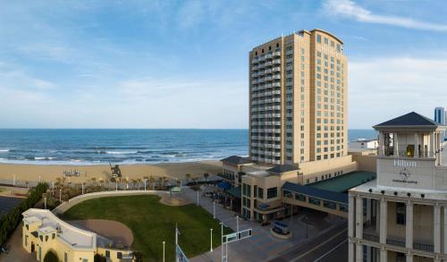 弗吉尼亚海滩弗吉尼亚海滩海滨希尔顿酒店的一座高大的建筑,背靠大海