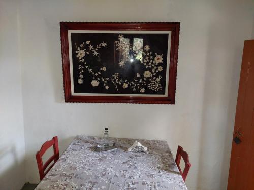 基萨莫斯Tree house nikiforos的一张桌子、两把椅子和一张墙上的照片