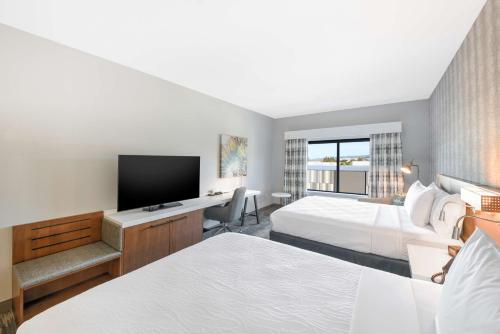 弗里蒙特Hilton Garden Inn Fremont Milpitas的酒店客房设有两张床和一台平面电视。