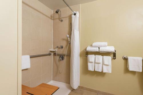 大急流城DoubleTree by Hilton Hotel Grand Rapids Airport的带淋浴和白色毛巾的浴室