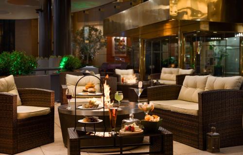 赫恩登华盛顿杜勒斯机场希尔顿酒店的大堂设有桌椅,提供食品和饮料