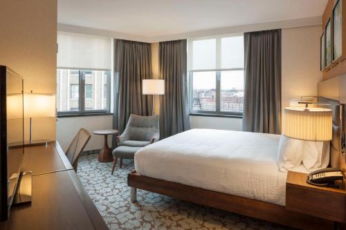皇后区Hilton Garden Inn Long Island City的配有一张床和一把椅子的酒店客房