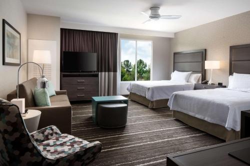 亚里索维耶荷亚里索维耶荷拉古纳海滩希尔顿惠庭套房酒店的酒店客房,配有两张床和椅子