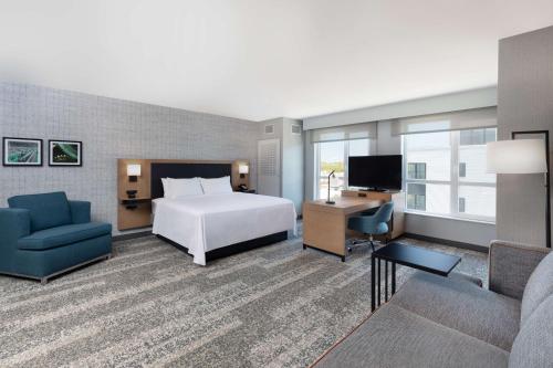 沃特敦Hampton Inn & Suites Watertown Boston, Ma的酒店客房设有一张床、一张书桌和一台电视机。