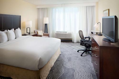 科默斯洛杉机希尔顿逸林酒店的配有一张床和一台平面电视的酒店客房