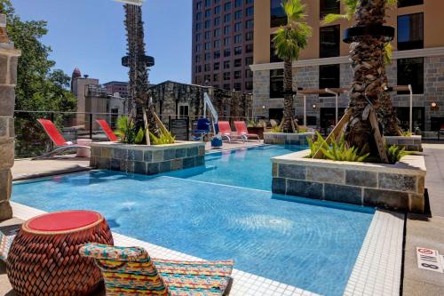 圣安东尼奥Home2 Suites By Hilton San Antonio Riverwalk的一座带椅子和棕榈树的游泳池