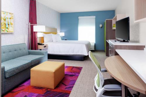 奥兰多Home2 Suites By Hilton Orlando South Park的酒店客房,配有床和沙发