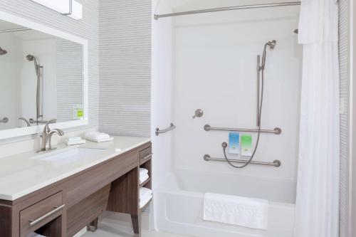 奥兰多Home2 Suites By Hilton Orlando South Park的白色的浴室设有浴缸和水槽。