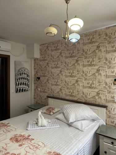 普洛耶什蒂Home Simoni的一间卧室配有一张大床,墙面上贴有壁纸