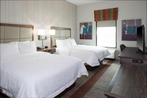 匹兹堡Hampton Inn & Suites Pittsburg Kansas Crossing的酒店客房设有两张床和一台平面电视。