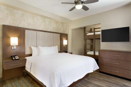 摩押莫布希尔顿惠庭套房酒店的一间卧室配有一张床和一台平面电视