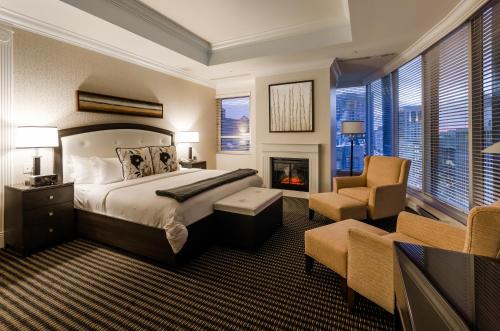 蒙特利尔圣马丁别墅酒店的一间卧室配有一张床、一个壁炉和一把椅子
