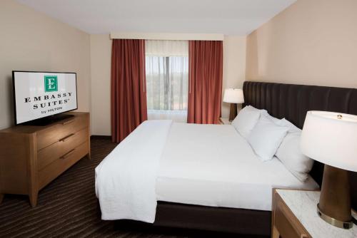 凤凰城Embassy Suites by Hilton Phoenix Scottsdale的酒店客房设有白色的床和窗户。