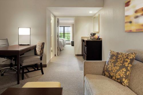 阿尔法利塔希尔顿亚特兰大阿尔法利塔使馆套房酒店的客厅配有沙发和书桌。