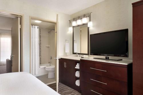 隆波克Embassy Suites by Hilton Lompoc Central Coast的一间带电视的卧室和一间带床的浴室
