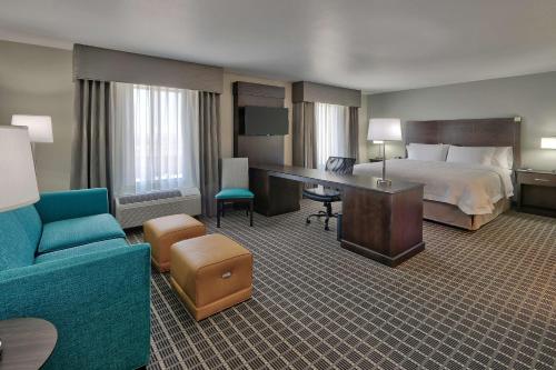 阿尔伯克基阿尔伯克基机场汉普顿酒店的配有一张床和一张书桌的酒店客房