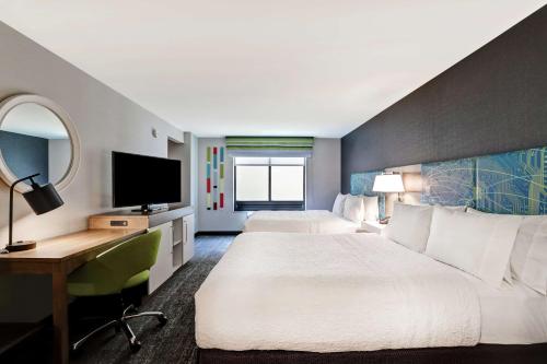 埃格港乡Hampton Inn Egg Harbor Township Atlantic City的酒店客房设有两张床、一张桌子和一台电视。