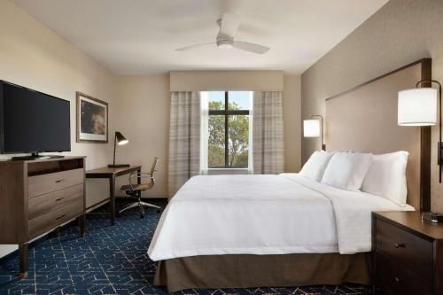 奥尔巴尼Homewood Suites by Hilton Albany Crossgates Mall的配有一张床和一台平面电视的酒店客房