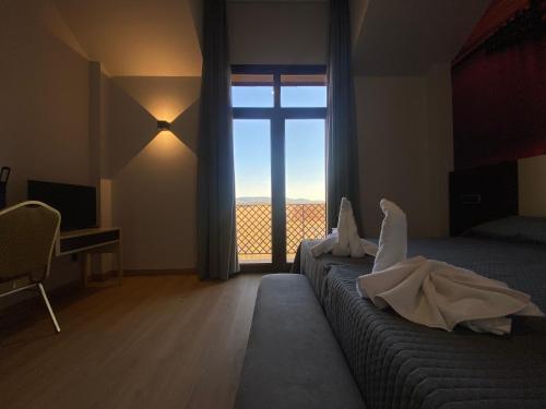 PulgarHotel-Asador Montes Oretanos的一间卧室设有一张大床和大窗户
