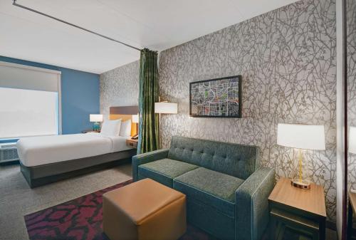 亚特兰大Home2 Suites by Hilton Atlanta Airport North的酒店客房设有一张沙发和一张床
