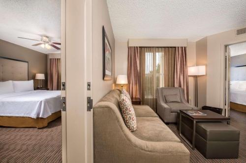奥斯汀Homewood Suites by Hilton Austin South的酒店客房配有床、沙发和椅子