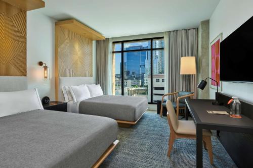 奥斯汀Canopy By Hilton Austin Downtown的酒店客房配有两张床和一张书桌