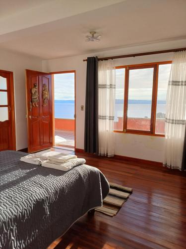 Isla de SolHostal Tawri的一间卧室配有一张床,享有海景
