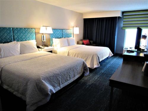 亚德利纽敦希尔顿恒庭旅馆&套房酒店的酒店客房设有两张床和电视。