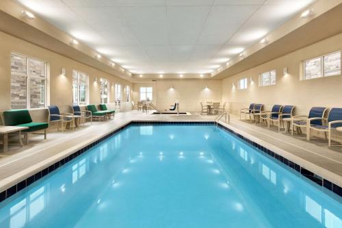 曼彻斯特Homewood Suites By Hilton Hartford Manchester的一个带椅子的大型游泳池和一间候机室