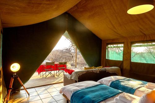 楚梅布ZuriCamp - Tent Zahir的一间帐篷内带两张床的卧室