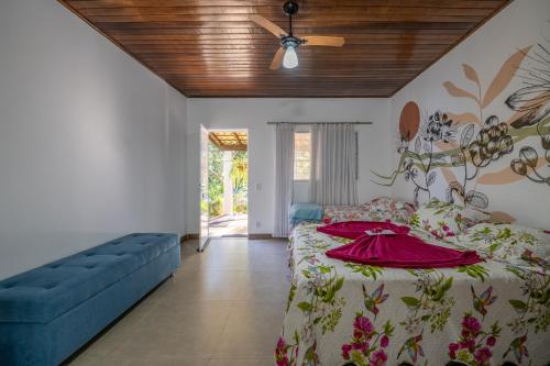 沙帕达-杜斯吉马朗伊斯Pousada Luz do Jamacá的一间卧室配有一张床和一张蓝色的沙发