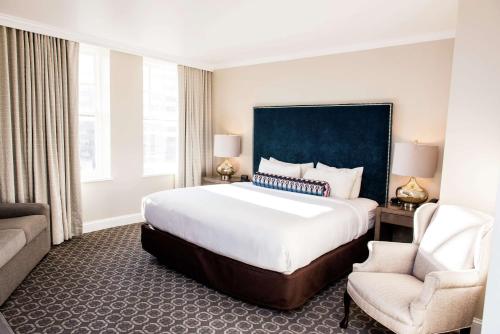 伯明翰Redmont Hotel Birmingham - Curio Collection by Hilton的酒店客房带一张大床和一把椅子